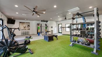 a home gym with a green carpet floor and a ceiling fan  at Knox Allen Station, Allen, TX